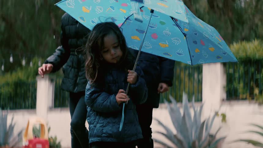 Three children play in the rain
