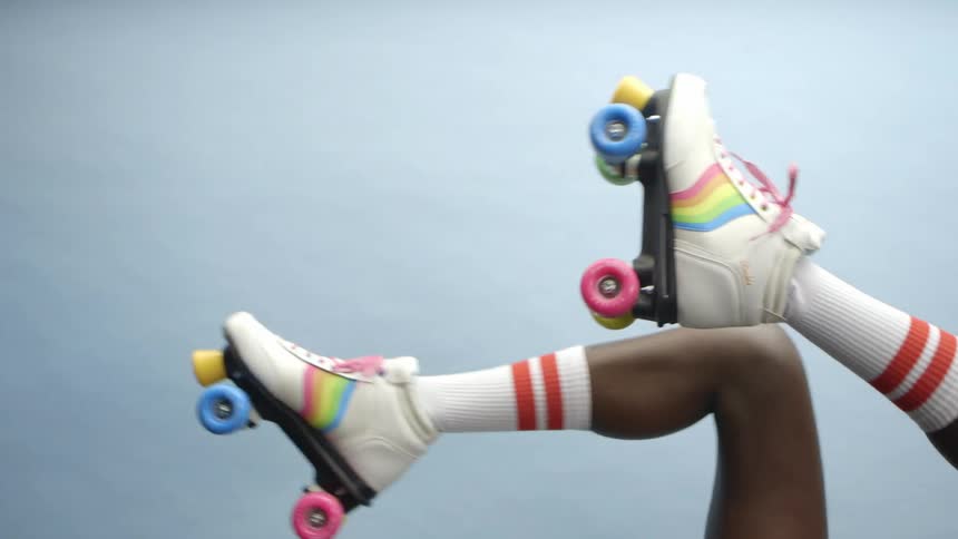 A woman wearing roller skates kicks a heart shaped balloon