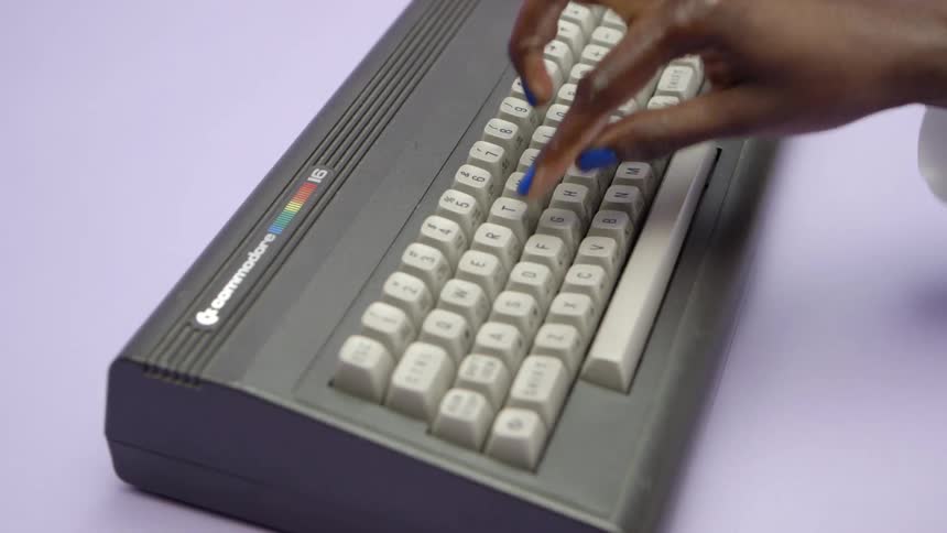 A womans hand typing on a keyboard