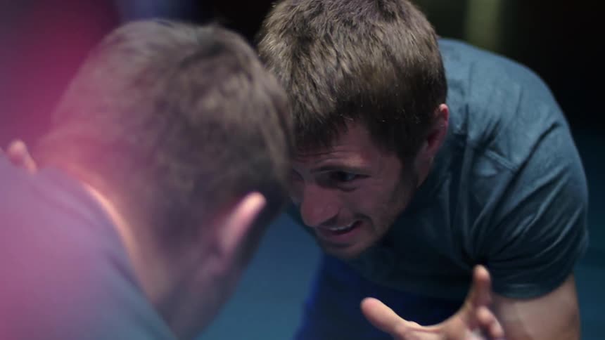 Two men wrestle indoors