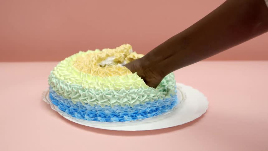 A person punching a cake and grinding their fist into it