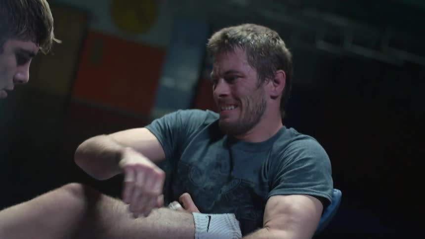 A man holds his opponent's leg while reaching for him
