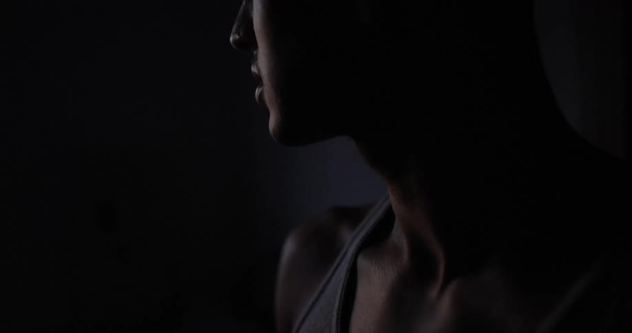 Man in darkness looks sideways