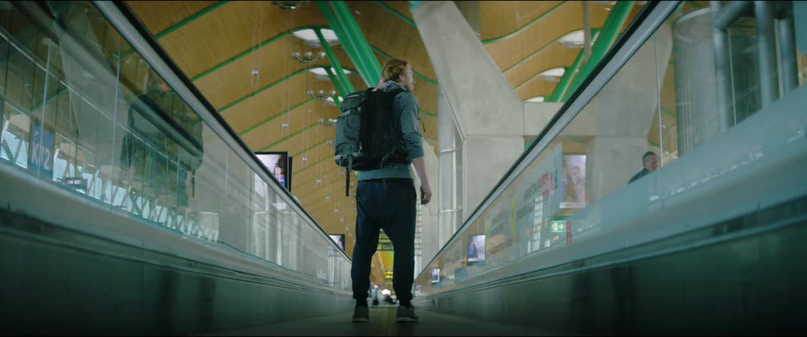 A man standing on a conveyor belt in an airport