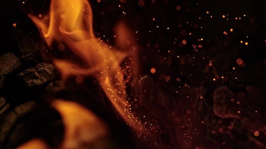 Fire and sparks leap around a wooden log