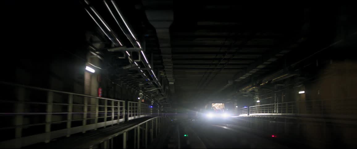 A subway train lumbers down a dark tunnel