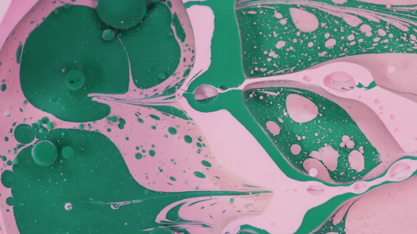 Green and pink paint floating on water