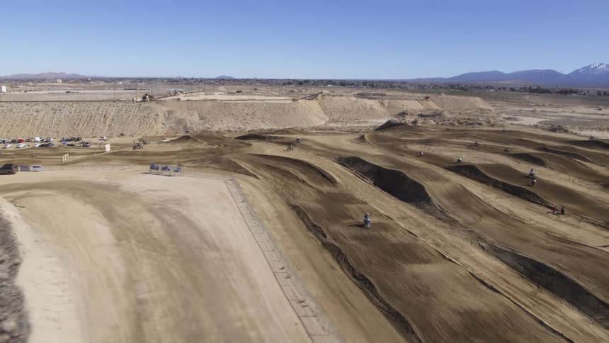 Several motocross racers race around a dirt track