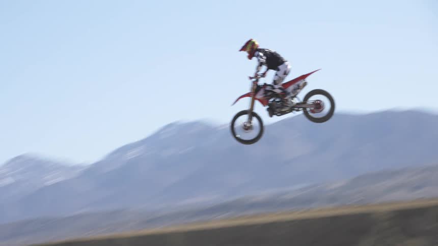 A man is doing tricks on a bike outdoors