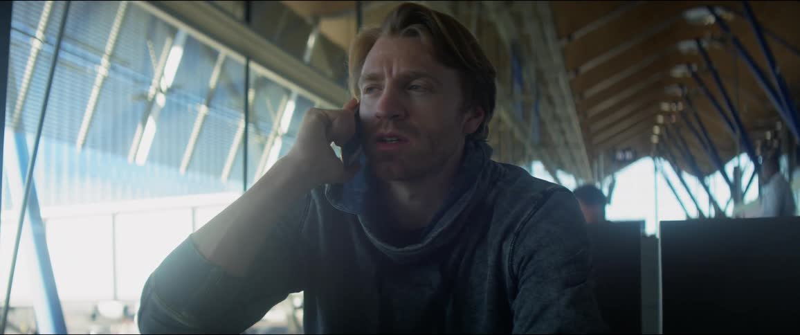 A man talking on the phone in an airport