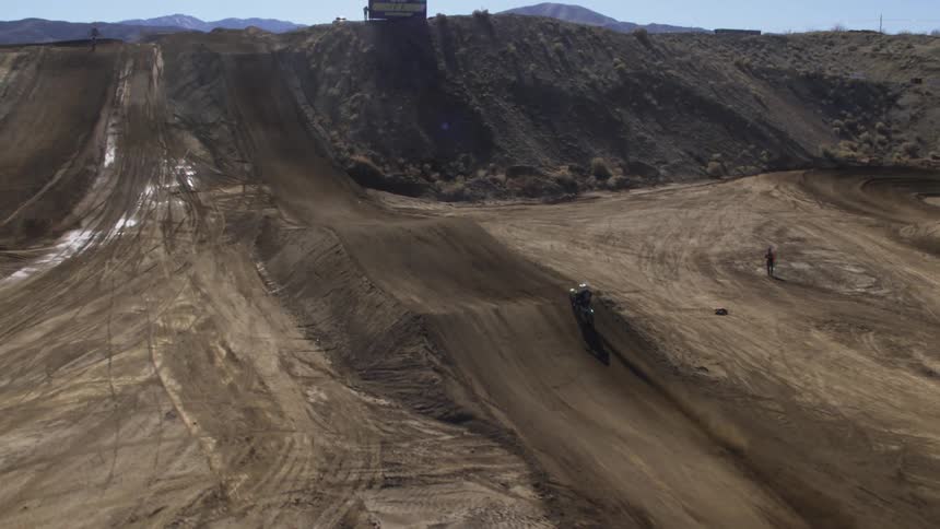A motorcyclist jumps an obstacle on a dirt racing track