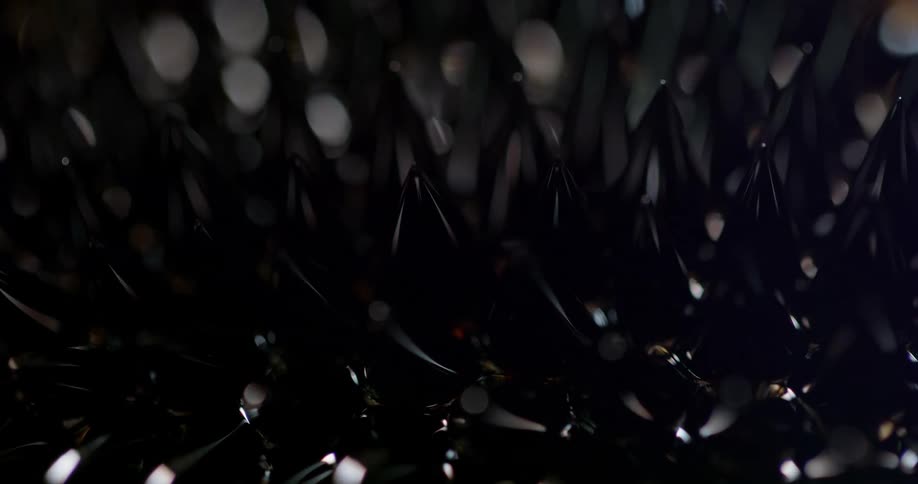 Shiny black pointed objects stand in rows