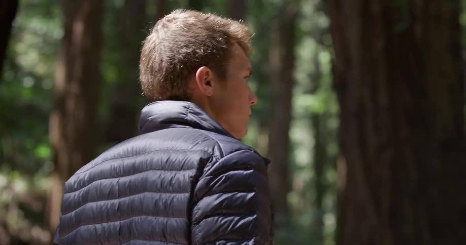 A man turns and walks in the forest