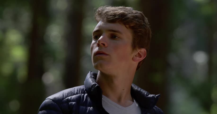Man looks around and thinks about something carefully in the woods