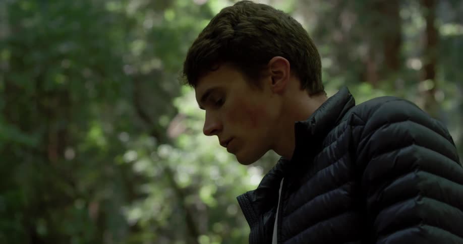 Man stoops down in the forest