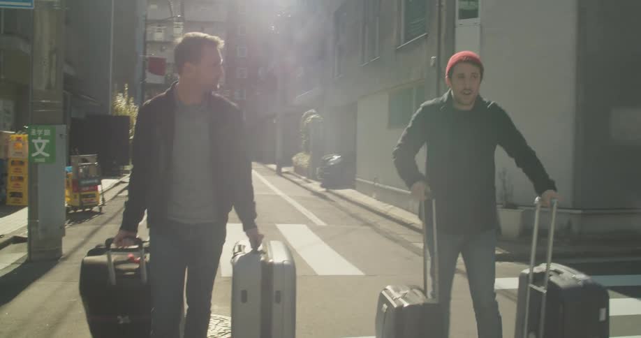Two men walk with luggage