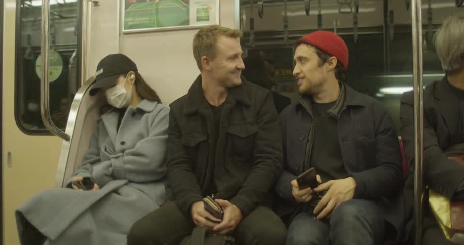 Two men talk on the subway