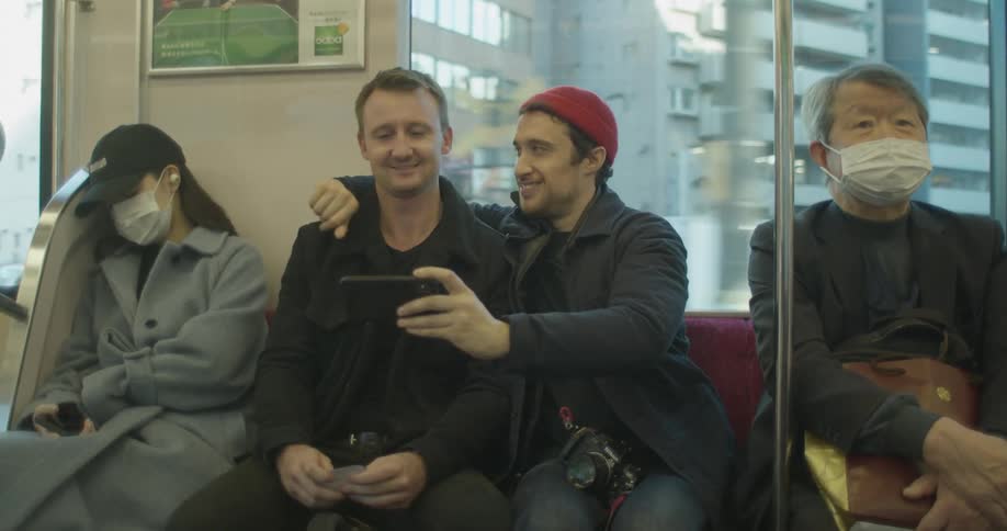 Two men take a selfie on a train