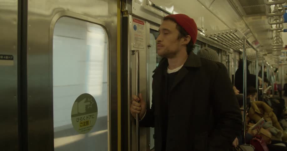 Man stands and uses a smartphone on the subway train