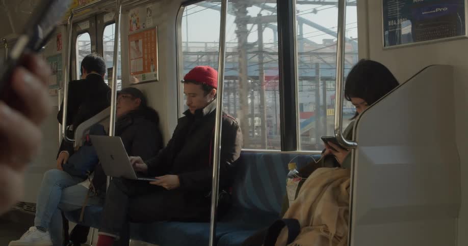 A man opens his laptop while riding the train