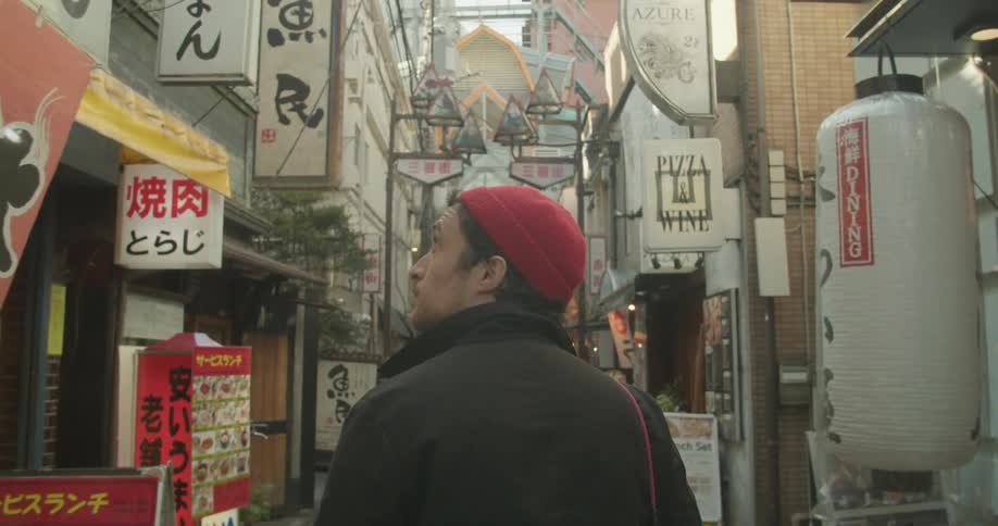 A man is walking through a foreign downtown area