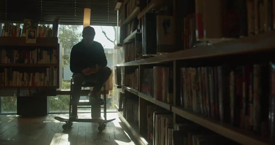 Man sitting in the chair uses his smartphone in the library