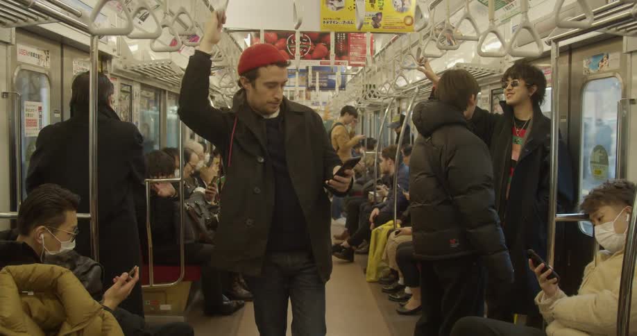 A person pulls out their cell phone while riding the train