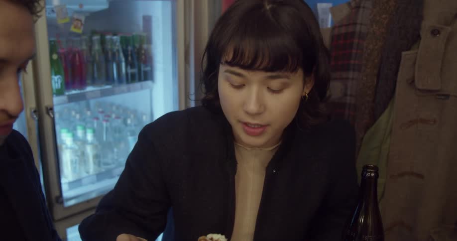 A couple sits at a small table in a restaurant and eats a meal