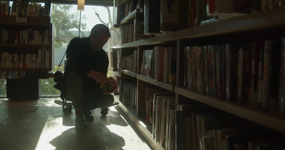 Man picks up a book to read from a library