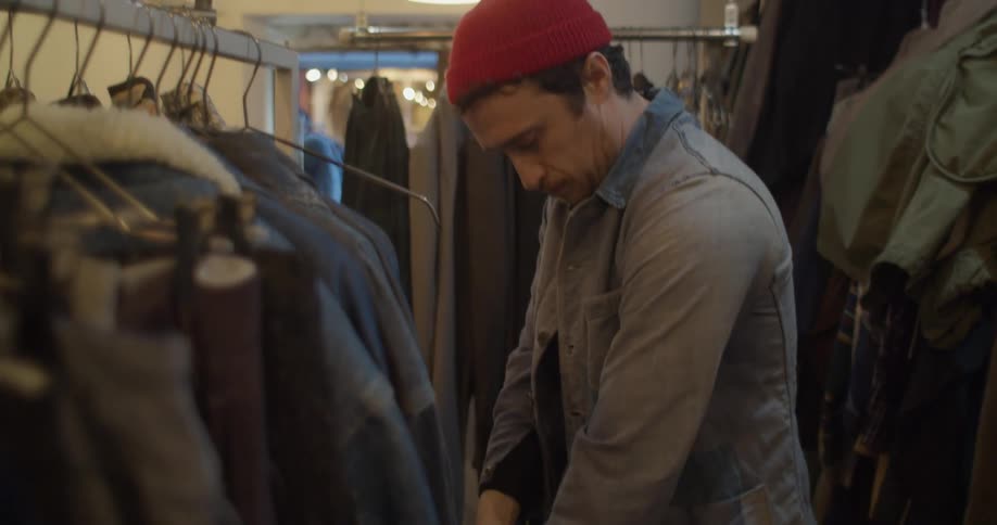 A man in a store trying on a jacket