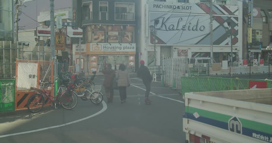 A person rides their skateboard into the city