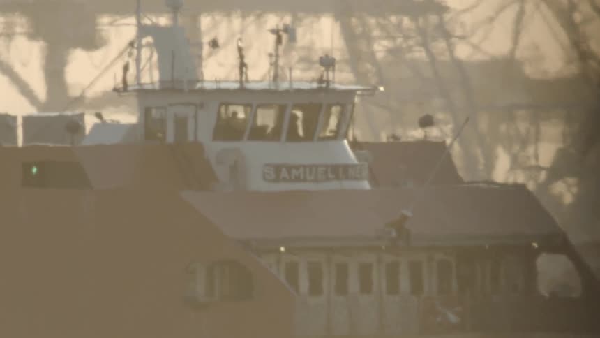 A ship rides along the port shore