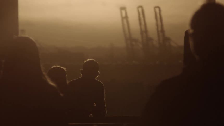 A silhouette of a man and a woman talking while people walk in the foreground
