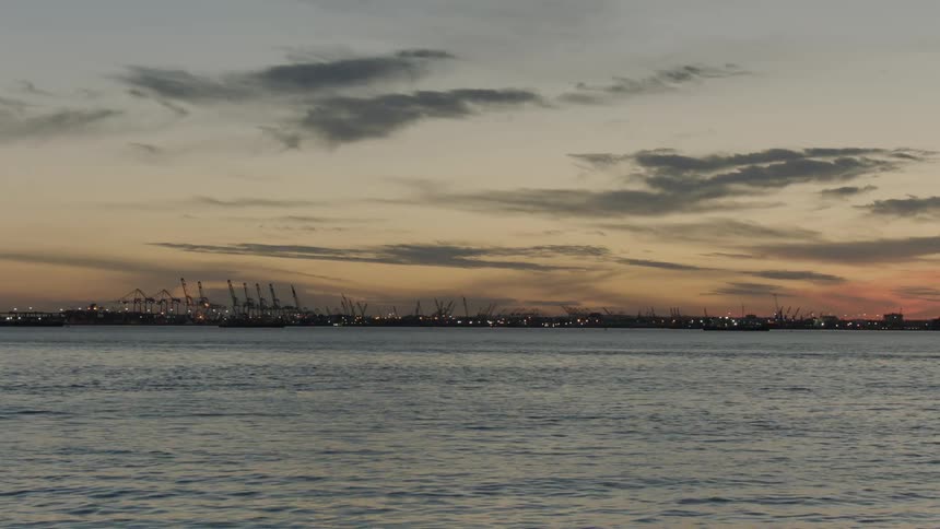Water flows while orange sky hovers over city