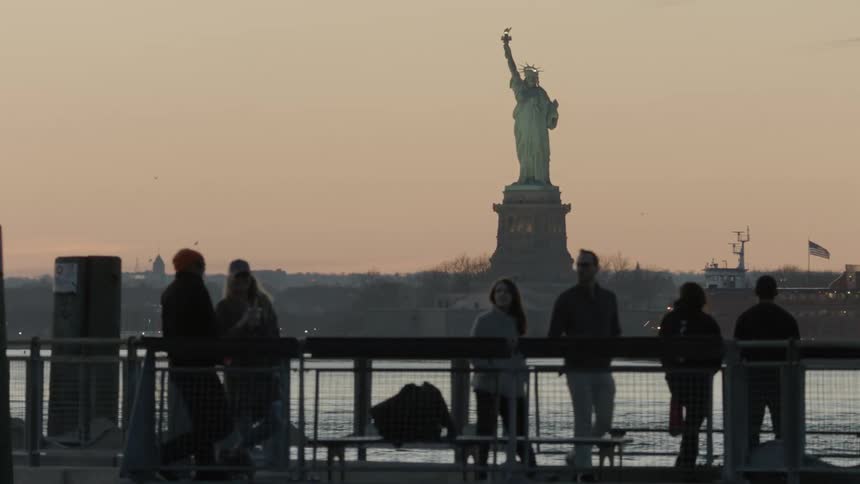 The people look at the statue of liberty from the shore