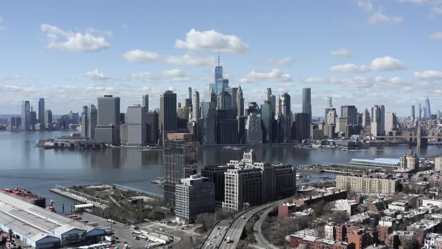 Skyscrapers loom into the air behind a body of water