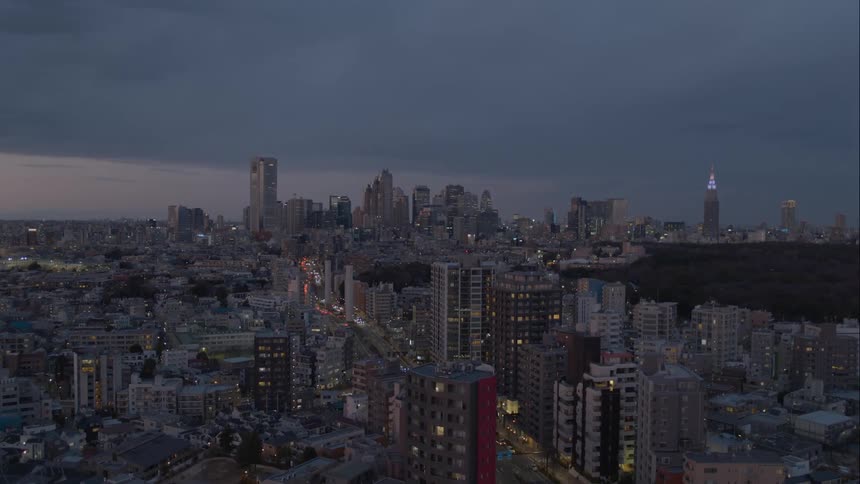 Traffic on city streets through downtown with the park and skyscrapers on the horizon