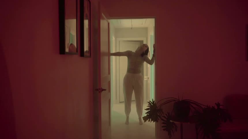 A teenager dances around her house as lights flash