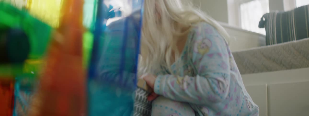 A little girl pulls toys out of a bin