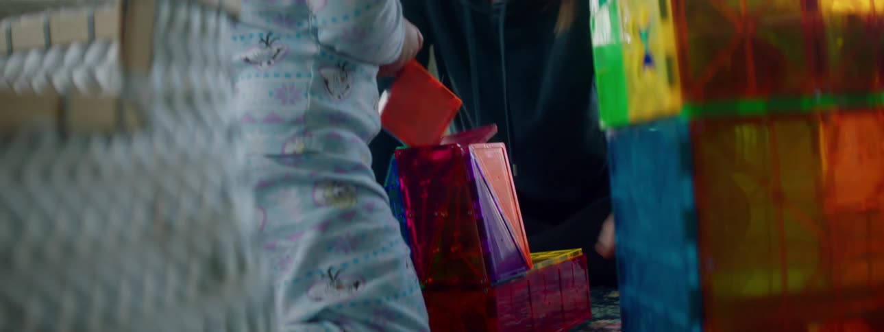 Mother and daughter play with toys in the living room at home