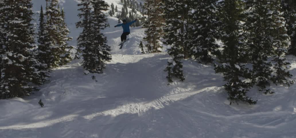 A skier jumps down a snow covered mountain