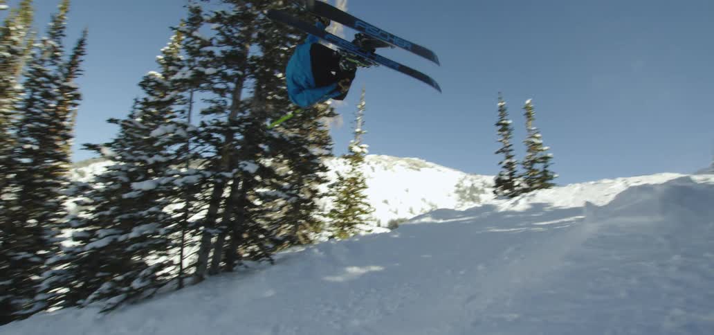 A skier performs a trick on a slope