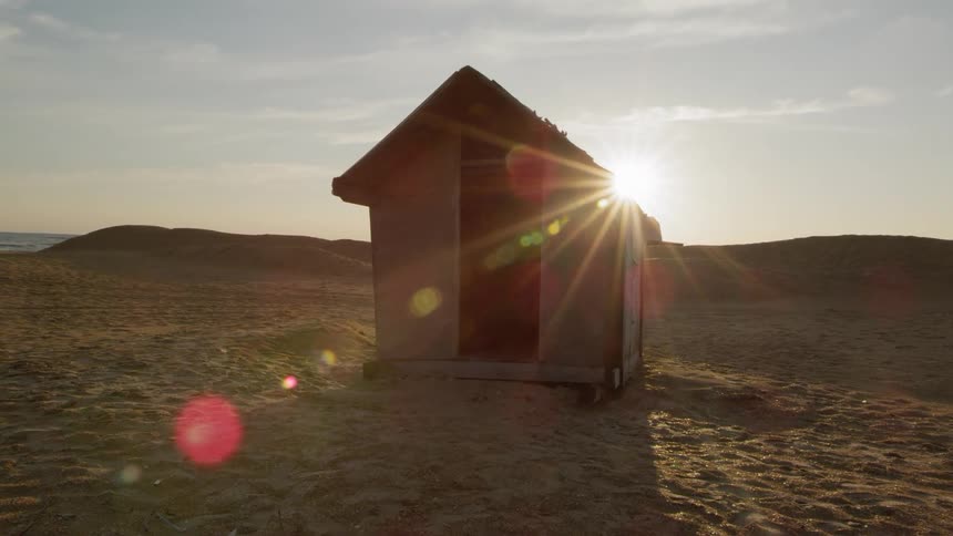 A raggedy wooden shack on an empty beach