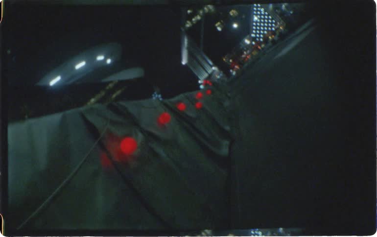 Red lights attached to the barrier next to the road at night