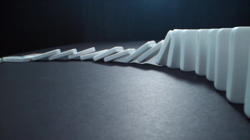 A row of dominoes tumbling with a black background