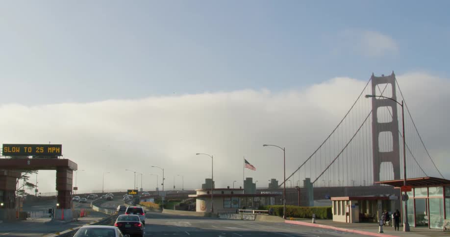 A road with vehicles with a bridge in the background