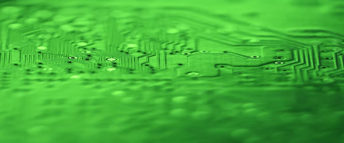 Green light reflects off a large circuit board