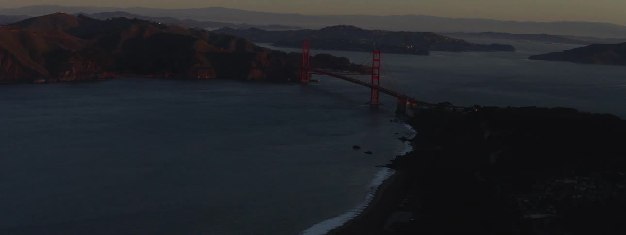 A dense neighborhood sits along the shore near the golden gate bridge