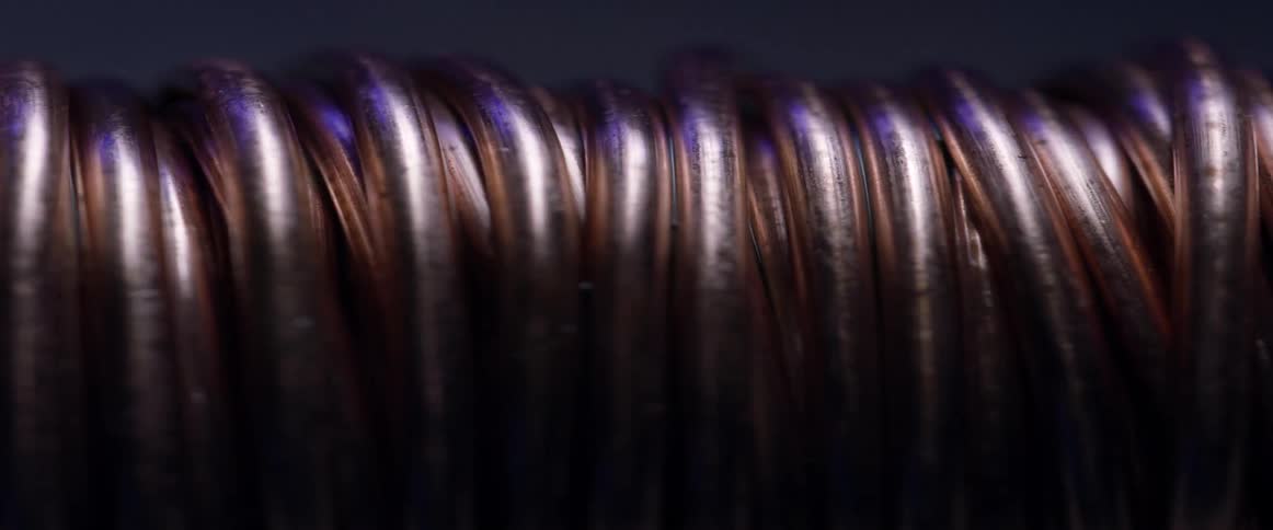 Light shines on tightly coiled copper colored wire