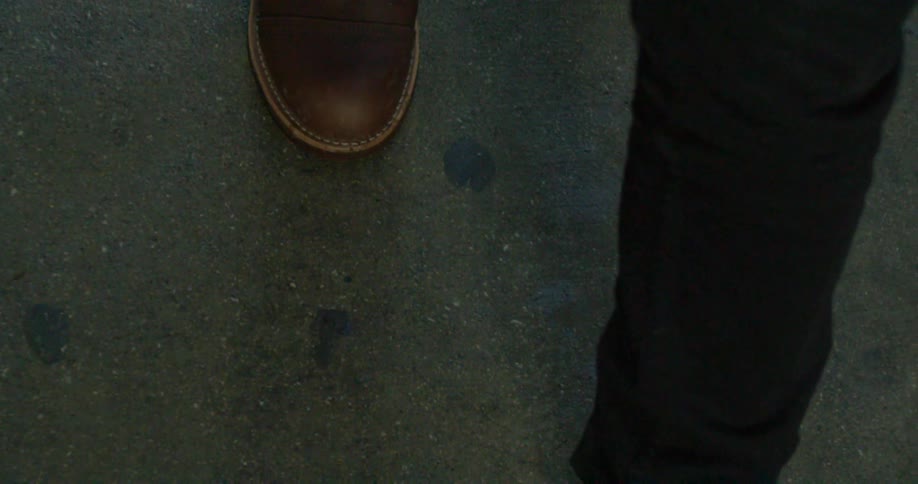 A person wearing boots is walking on a street